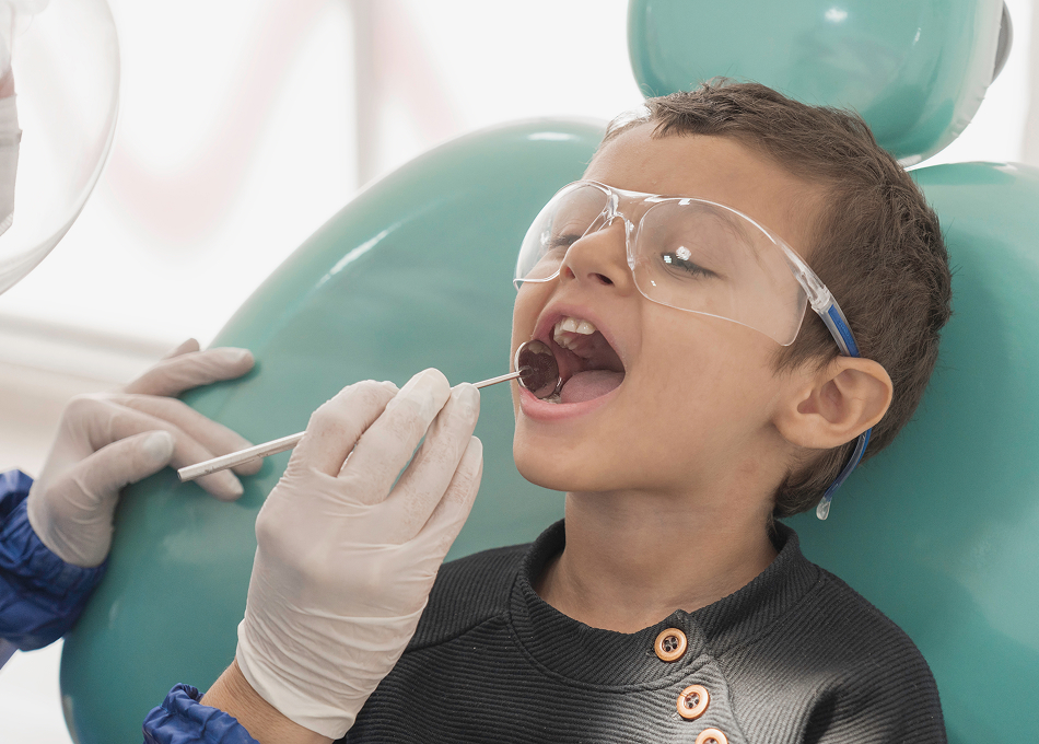 Boy in protective glasses during a gentle dental exam